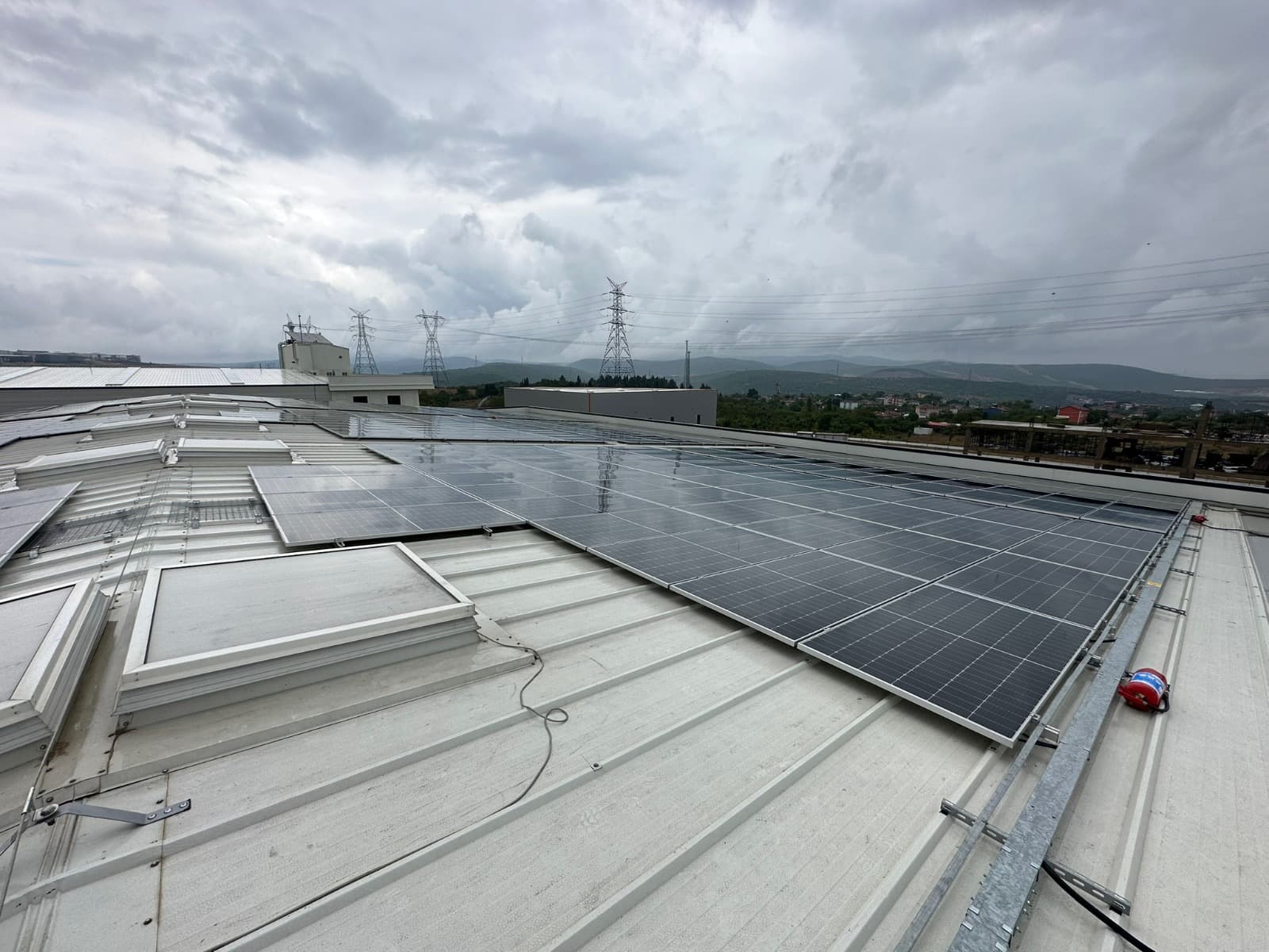 Fabrika çatısında devam eden panel montajı